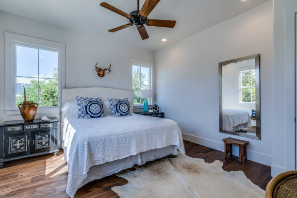 istock Ceiling fan and crisp white walls and bedding 1288564345