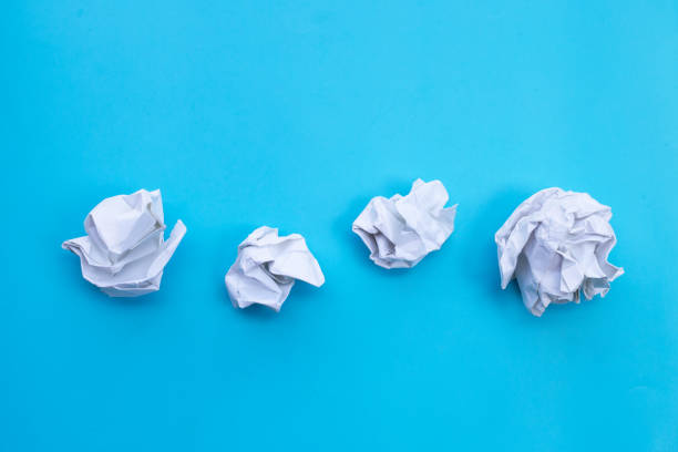 istock White crumpled paper on blue background. Ideas and creative thinking concept. Top view 1288564458