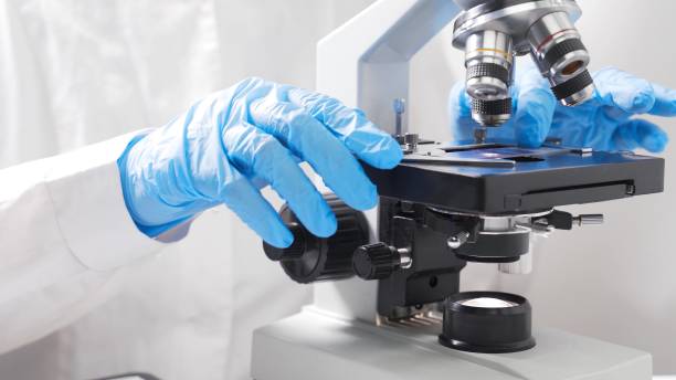 istock A scientist analyzes a blood sample with a microscope. Concept - epidemic, drug and vaccine development 1288565364