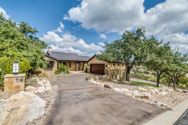 istock Long driveway leading to light yellow exterior home 1288565441