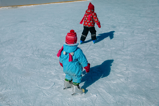 little girls skating in winter, family seasonal sport