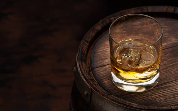 istock Scotch whiskey glass and old barrel 1288575357
