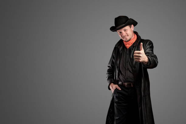 istock Cowboy in leather clothing shows a hand gesture. 1288575650