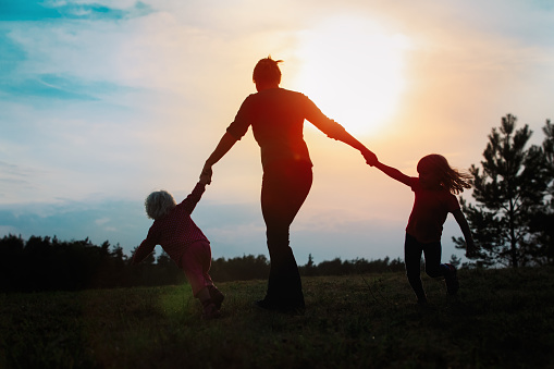happy mother with kids play in nature, family enjoy sunset