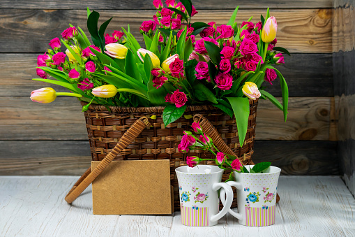 beautiful bouquet of flowers red roses and tulips in a wooden basket