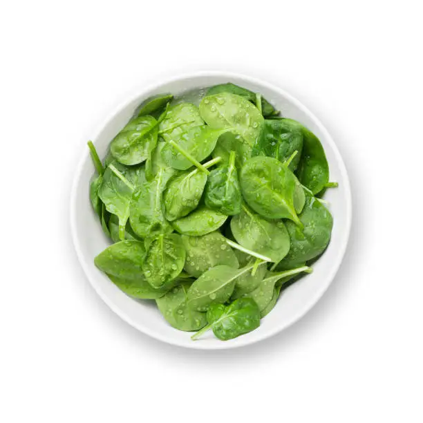 Spinach salad in bowl. Isolated on white background. Top view flat lay
