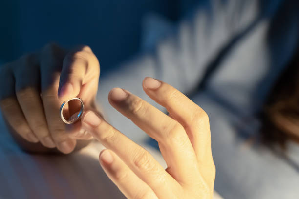 depressed woman hold wedding ring - anulação do casamento imagens e fotografias de stock