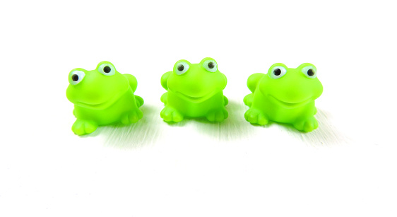 children's toys three green rubber frog, white background