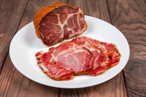 collo di maiale essiccato parzialmente affettato su piatto, messa a fuoco selettiva - dry cured ham foto e immagini stock