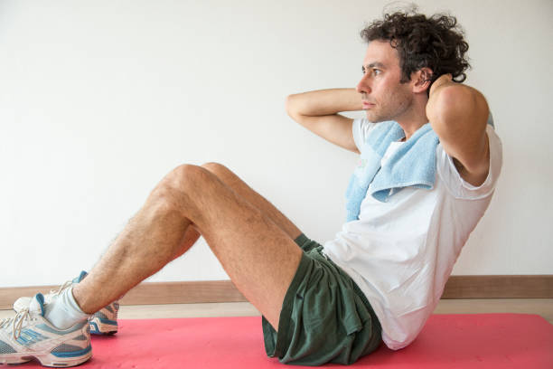 istock young man doing gym exercises at home 1288584046
