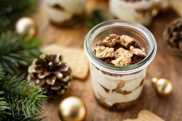 Tiramisu with spekulatius in a dessert glass Tiramisu with spekulatius in a dessert glass. Close up. Decorated with pine cones, branches and christmas balls. Part of a series tiramisu glass stock pictures, royalty-free photos & images