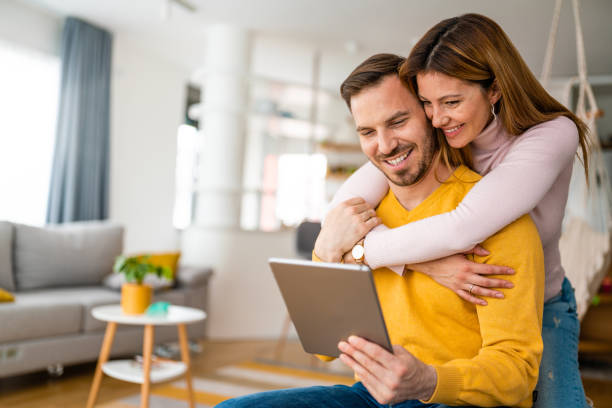 istock Couple in love hugging and using tablet together. 1288587404
