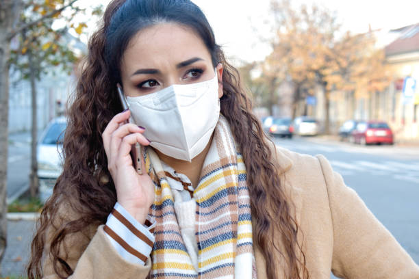istock Woman with a face mask outdoors talking on phone 1288588715