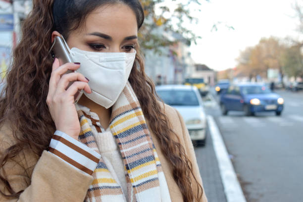 istock Woman with a face mask outdoors talking on phone 1288588774