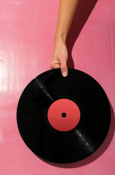 istock Woman holding vynil record against bright pink background. Hard light 1288589428