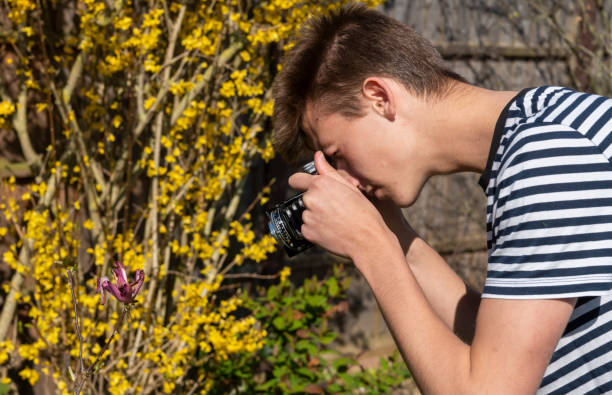 young man in a garden with a vintage medium format film camera - bellow camera photography photography themes photographer imagens e fotografias de stock