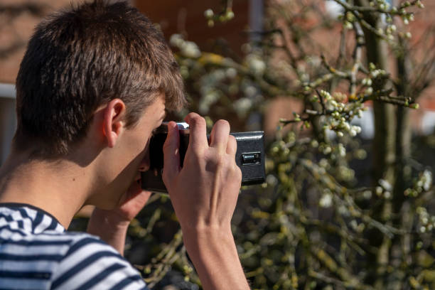 young man in a garden with a vintage medium format film camera - bellow camera photography photography themes photographer imagens e fotografias de stock