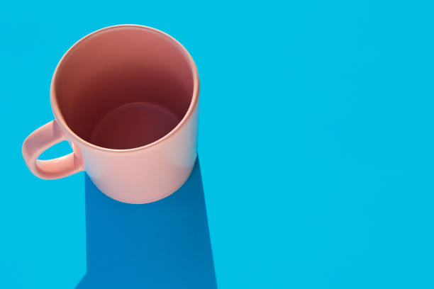 istock Pink mug over a blue background. Morning breakfast. Design pottery 1288592706