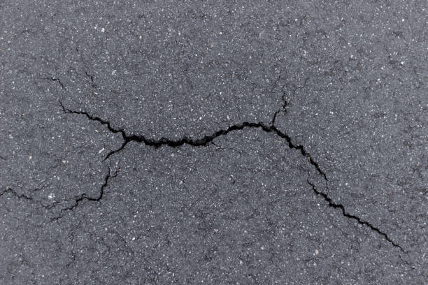 istock crack ana black asphalt, background, place for text 1288595298