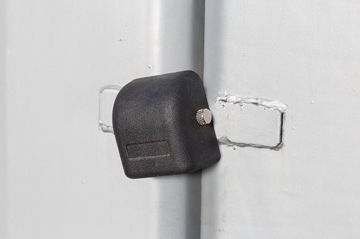 Locked padlock with rod, which sliding to the side to unlock hanging on the closed metal gate outdoors