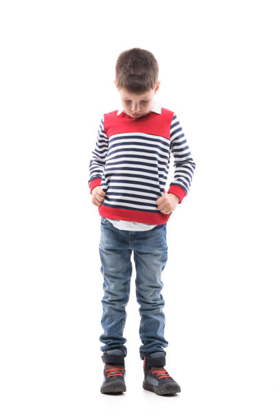 Sad disappointed little kid with bowed head looking down and complaining. Sad disappointed little kid with bowed head looking down and complaining. Full body portrait isolated on white background. sad child standing stock pictures, royalty-free photos & images