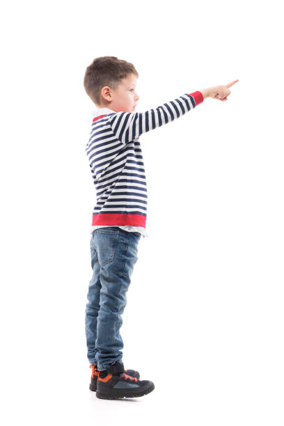istock Side view of little boy pointing finger and looking ahead. 1288597000