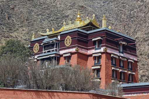Xiahe, Gansu Province / China - April 28, 2017: Temple building at Labrang Monastery. With golden colored and richly ornamented rooftop - tibetan style architecture.
