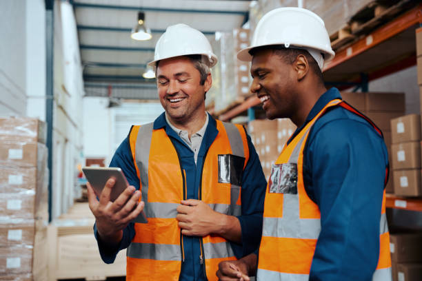 istock Multiethnic factory engineers smiling while looking at digital tablet screen at industrial warehouse 1288598237