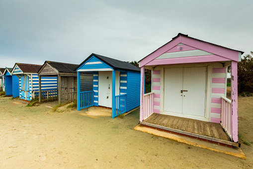 A selection of colorful, unique wooden beach huts on the south coast of England in winter. Room for copy space.
