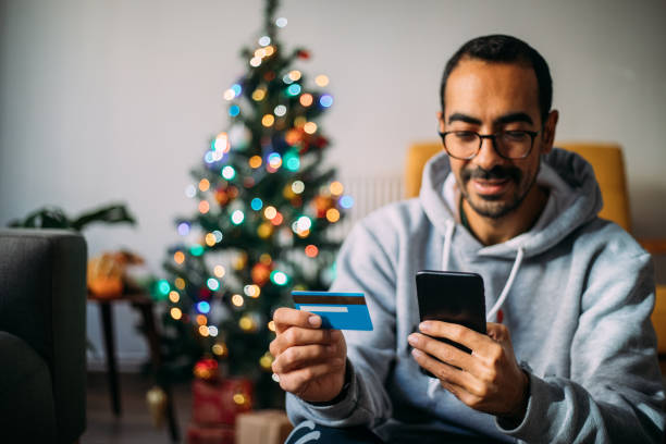 istock Man Using Phone For Christmas Shopping From Home 1288601734