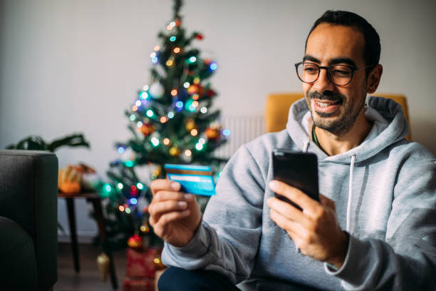 istock Man Using Phone For Christmas Shopping From Home 1288601806