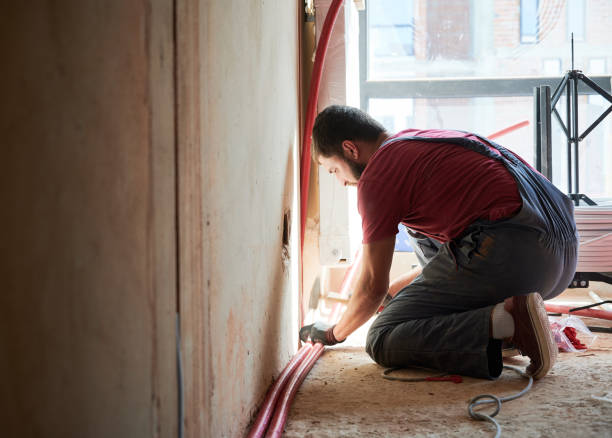 istock Male worker installing radiator in a new empty room next to the window 1288603211