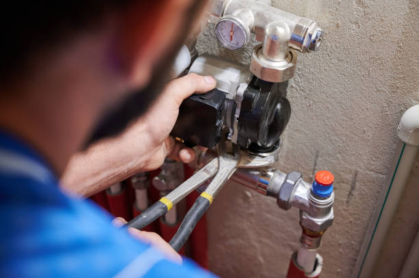 Male plumber installing heating radiator in apartment. Close up of worker hands using wrenches, installing water pump in apartment. Man plumber working on heating system installation. Concept of radiator installation, plumbing works and home renovation. water pump stock pictures, royalty-free photos & images