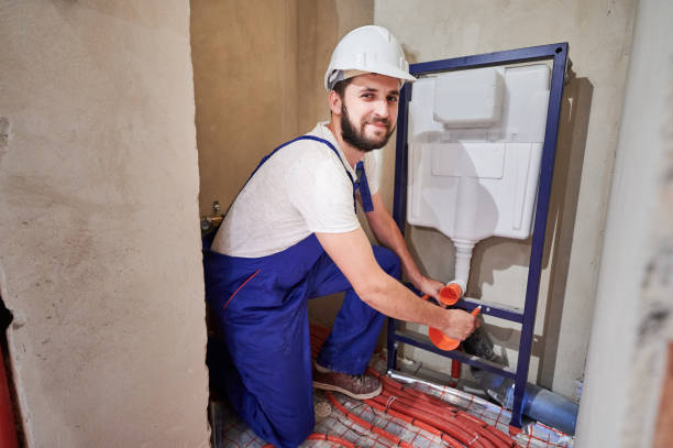 istock Joyful plumber installing wall-hung toilet system in bathroom. 1288603269