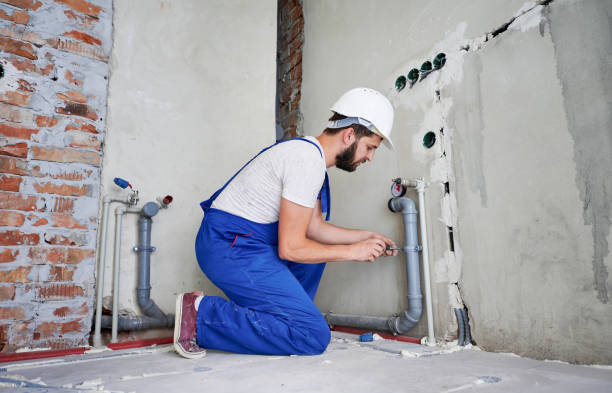 istock Young plumber working with grey sewer pipes, fixing them to wall 1288603271