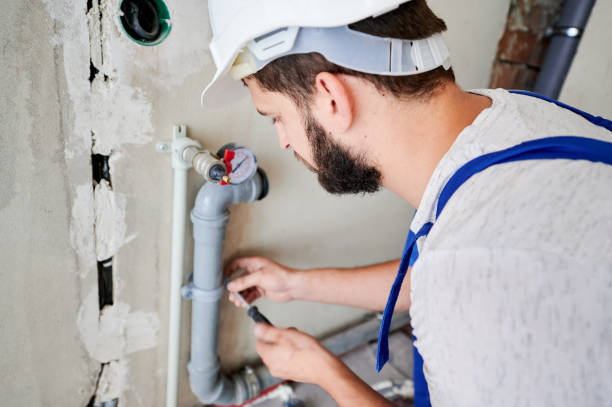istock Young plumber working with grey sewer pipes, fixing them to wall 1288603275