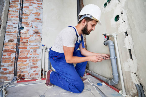 istock Young plumber working with grey sewer pipes, fixing them to wall 1288603282