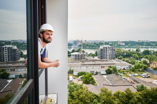 istock Male worker leaning out of the window. 1288603316