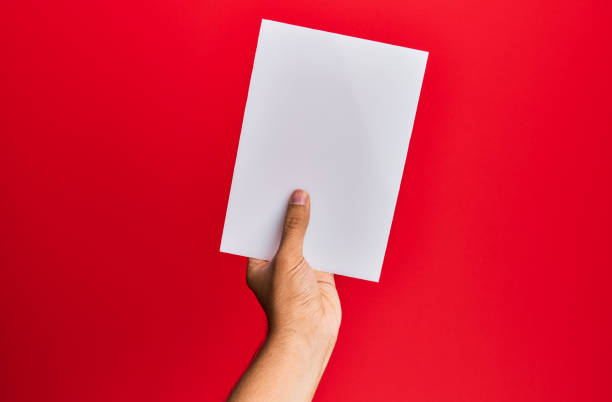istock Hand of young hispanic man holding empty banner over isolated red background. 1288604017