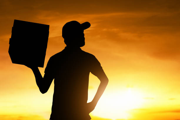 istock Silhouette of delivery man at sunset 1288604191
