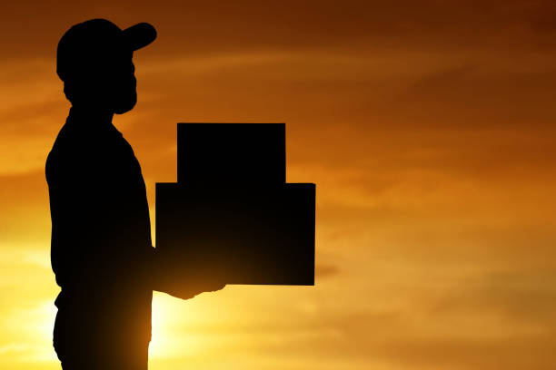 istock Silhouette of delivery man at sunset 1288604194