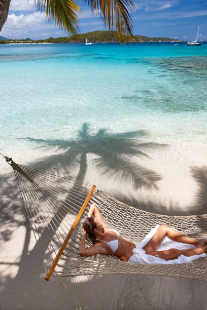 istock Woman relaxing in a hammock on a pristine tropical beach 1288605568