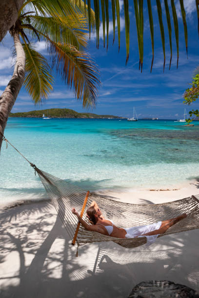 istock Woman relaxing in a hammock on a pristine tropical beach 1288605570