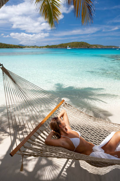 istock Woman relaxing in a hammock on a pristine tropical beach 1288605577