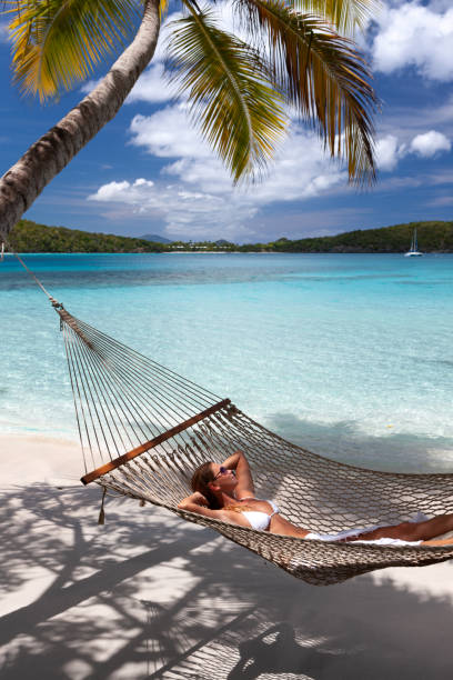 istock Woman relaxing in a hammock on a pristine tropical beach 1288605582