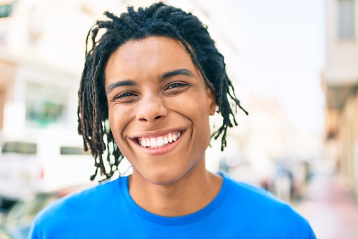 Young african american man smiling happy looking to the camera at street of city.