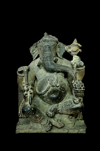 An ancient jade carving of the Hindu diety Ganesha isolated on a black background in Mumbai.