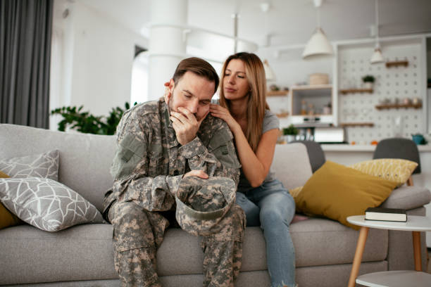 istock Depressed soldier sitting on sofa in living room. 1288608151