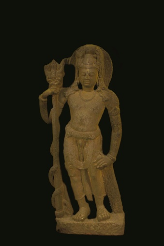 An ancient sculpture of the Hindu God Shiva isolated on a black back ground