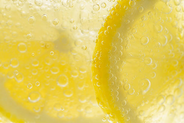 Sliced lemon in carbonated water Sliced lemon in carbonated water carbonated stock pictures, royalty-free photos & images